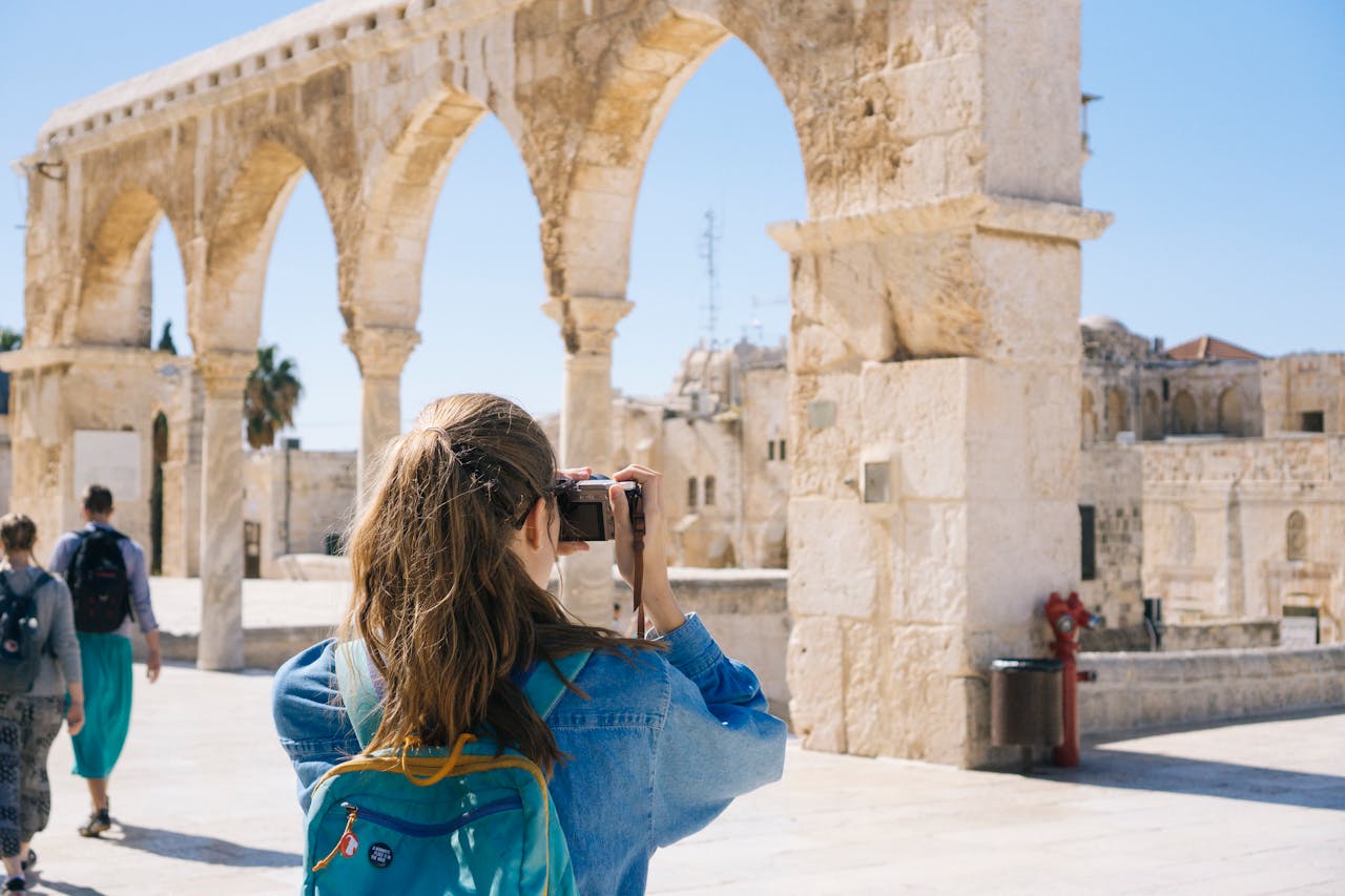 A tourist photographs the ancient stone arches in Jerusalem